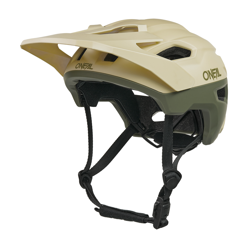 Der O'NEAL TRAILFINDER EVO Helm SOLID ist ein beiger und olivgrüner Mountainbike-Helm mit einem Visier, mehreren Belüftungsöffnungen, verstellbaren schwarzen Kinnriemen und ist mit dem optionalen Quin Smart Safety Sensor kompatibel.