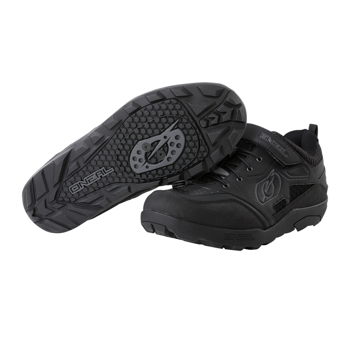 Zwei schwarze O'NEAL TRAVERSE SPD Schuhe-einer aufrecht, einer auf der Seite zeigt die strukturierte Sohle und Cleat Mount. Diese O'NEAL Radschuhe haben Schnürsenkel, einen Klettverschluss, Branding und bieten maximalen Schutz.