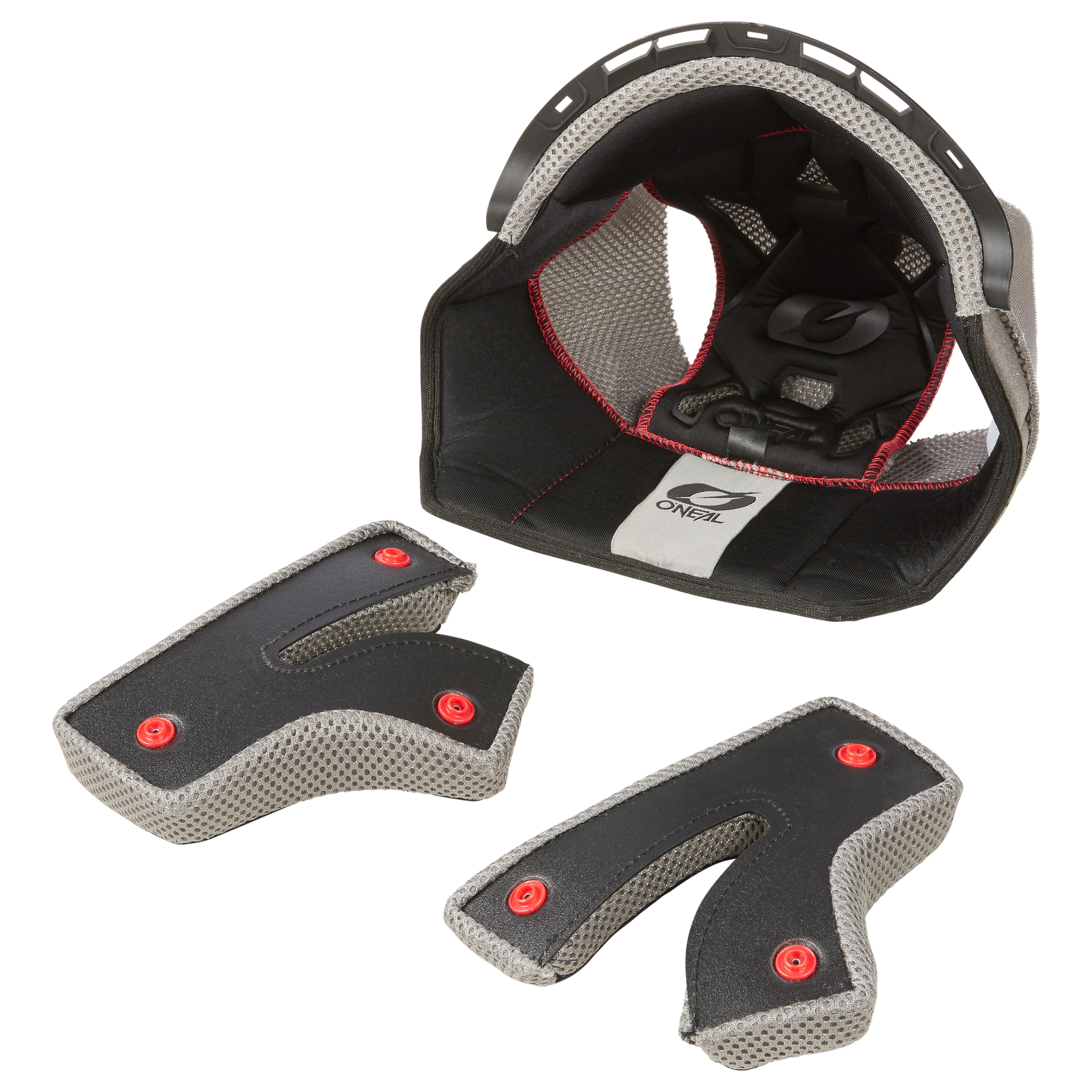 Dieses Bild zeigt Bestandteile der O'NEAL Liner & Cheek Pads für den BACKFLIP Helm von O'NEAL. Das Mittelteil besteht aus der Ober- und Hinterpolsterung mit Mesh-Innenfutter und Etikett, davor sind zwei einzelne Wangenpolster mit Mesh-Innenfutter und roten Knöpfen positioniert.