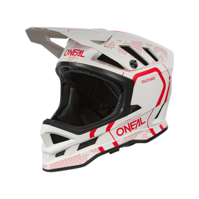 Der O'NEAL BLADE Polyacrylite Helm STRIKE - ein weißer MTB-Helm mit roten Akzenten, Visier und stabilem Kinnschutz - ist mit dem O'NEAL-Logo an der Seite und einem schwarzen Hintergrund versehen und eignet sich perfekt für Motocross oder Mountainbiking.