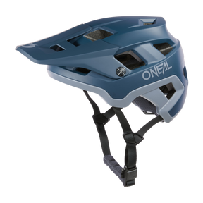 Der O'NEAL DEFENDER Helm SOLID ist ein blauer Fahrradhelm mit Visier, Belüftungsöffnungen, verstellbaren schwarzen Riemen und modernem Design, der zuverlässigen Schutz für Ihre Fahrten bietet.