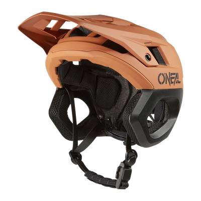 Ein mattorange-schwarzer O'NEAL TRAPPER Helmet SOLID Mountainbike-Helm mit Visier, Kinnschutz und verstellbarem Riemen wird von der Seite vor einem schwarzen Hintergrund gezeigt.