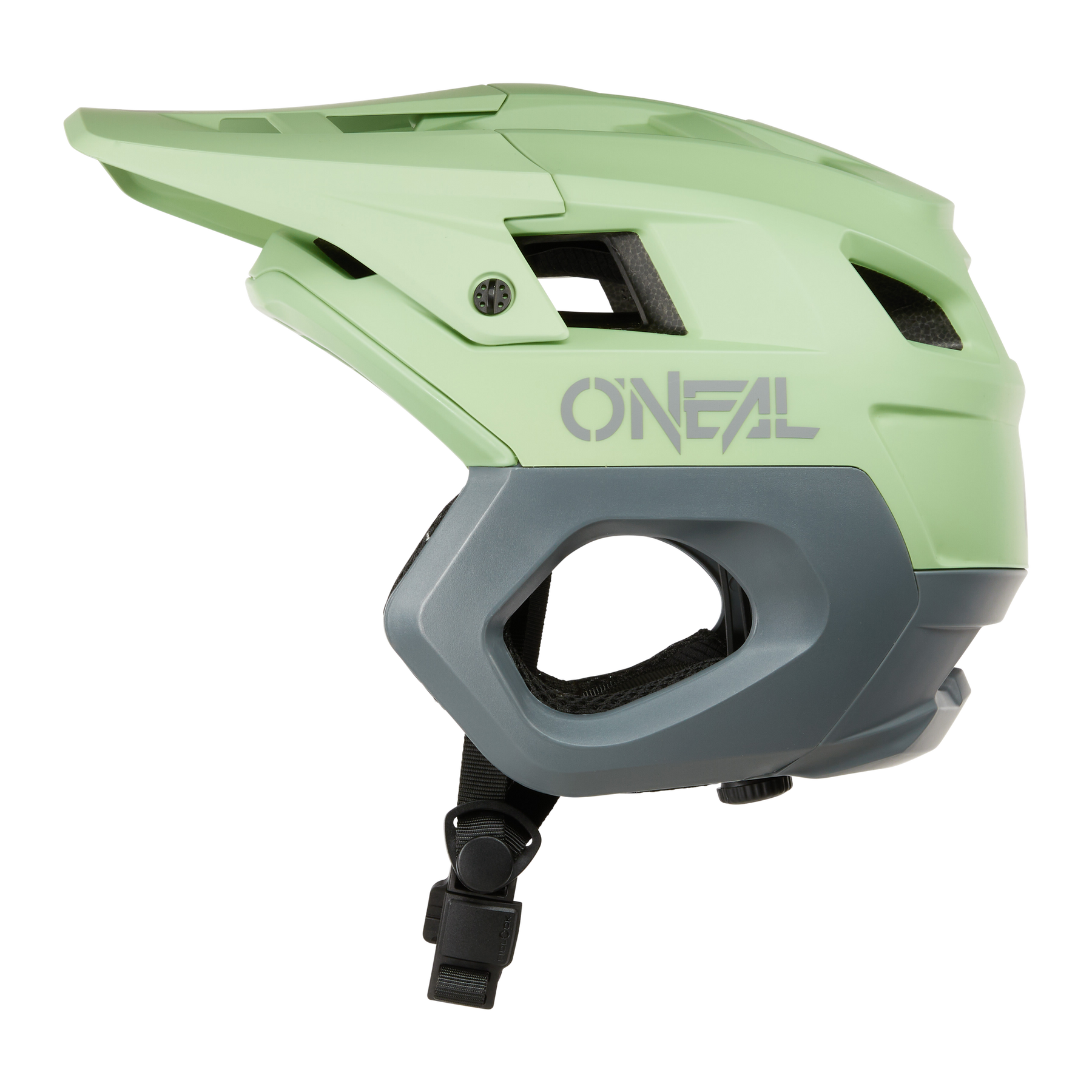 Der O'NEAL TRAPPER Helmet SOLID in Hellgrün und Grau verfügt über ein Visier, einen verstellbaren Kinnriemen und Belüftungsöffnungen. Er ist von der Seite auf weißem Hintergrund abgebildet und eignet sich perfekt für vielseitige Enduro- und Offroad-Mountainbike-Fahrten.