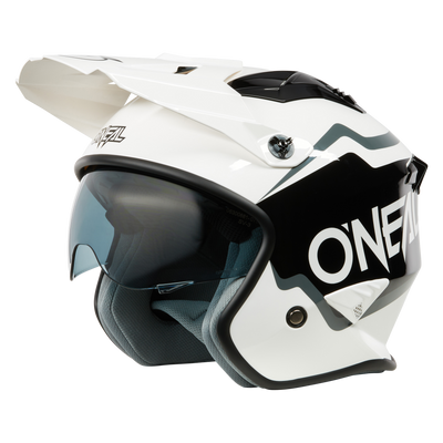Der O'NEAL VOLT Helm CORP ist ein schwarz-weißer Motocross-Helm mit großem Visier, getöntem Gesichtsschild und aerodynamischem Design, der von der Seite auf einem einfarbigen Hintergrund gezeigt wird.