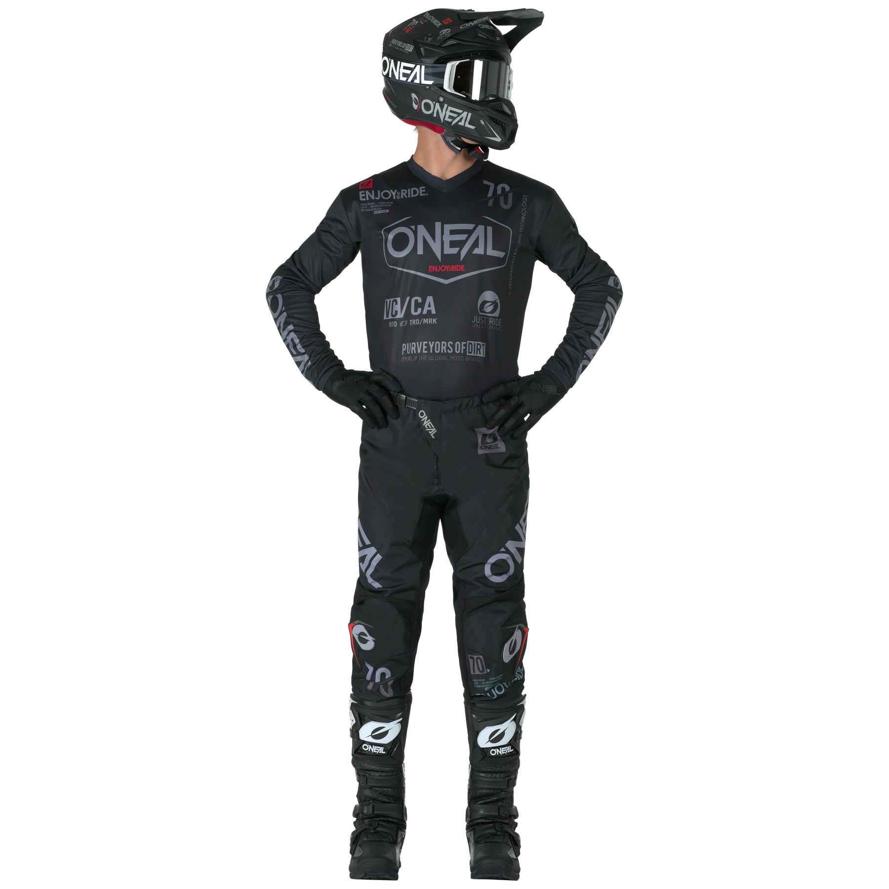 Eine Person in voller schwarzer O'NEAL-Ausrüstung, einschließlich der O'NEAL ELEMENT Pants BRAND, Helm, Handschuhen und Stiefeln, steht mit den Händen in den Hüften und schaut leicht nach links.