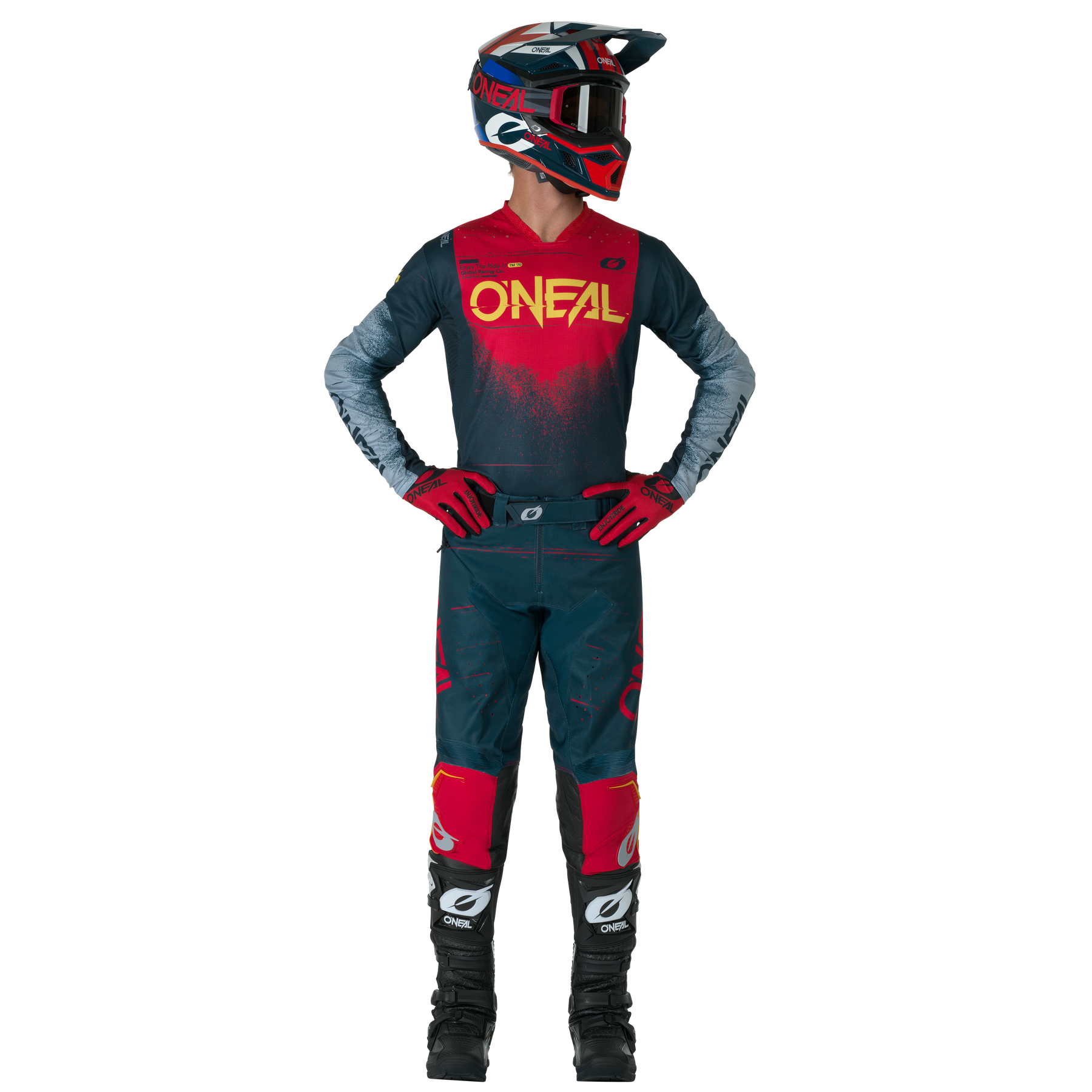 Eine Person in einem kompletten Motocross-Outfit, bestehend aus O'NEAL HARDWEAR Pants SWIPE und einem passenden Trikot, Handschuhen, Stiefeln und Helm, steht mit den Händen in den Hüften und schaut zur Seite.