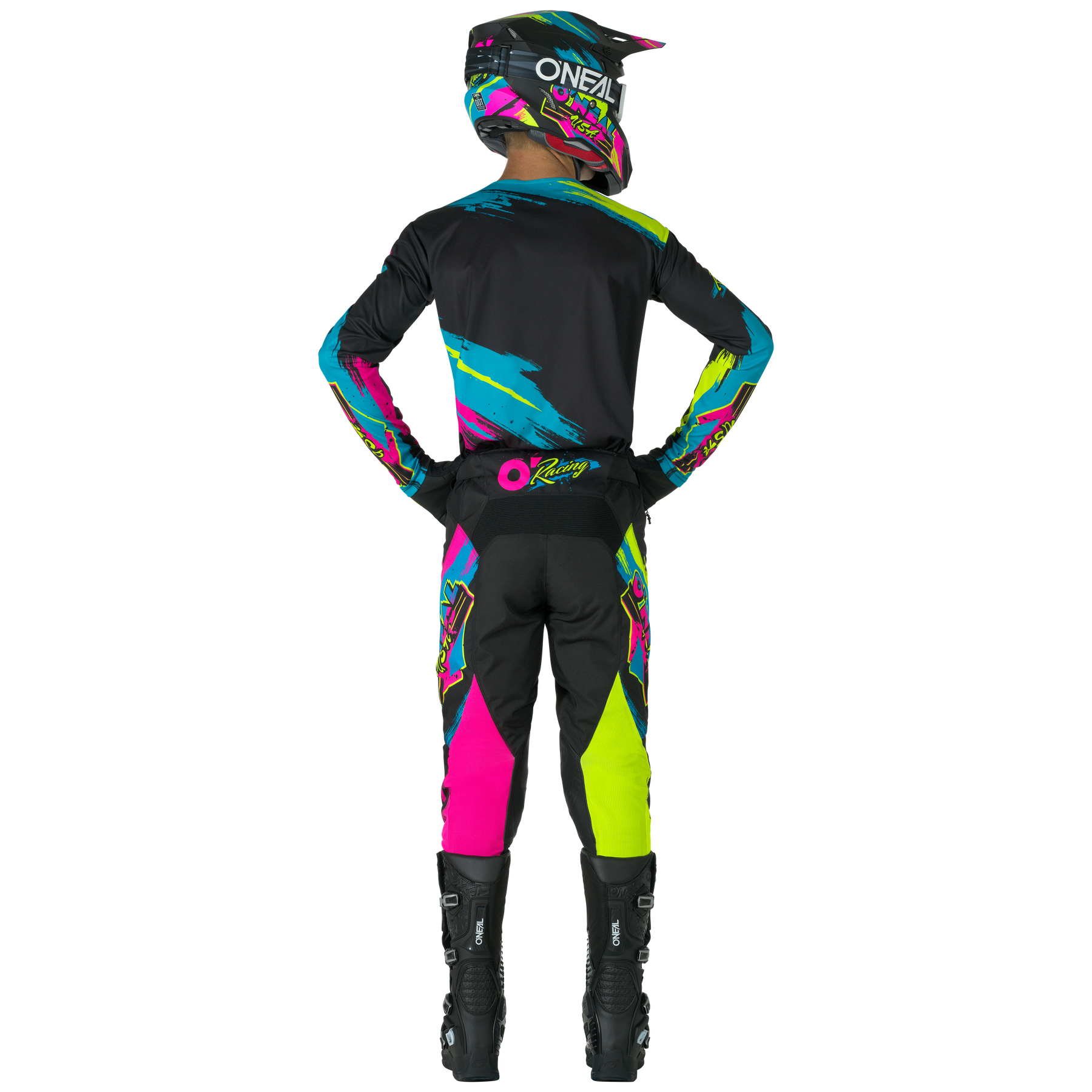 Eine Person, die die O'NEAL MAYHEM Pants RESEDA von O'NEAL mit leuchtenden blauen, pinken, gelben und schwarzen Mustern trägt, steht mit den Händen auf den Hüften von der Kamera abgewandt in einem kompletten Motocross-Outfit.