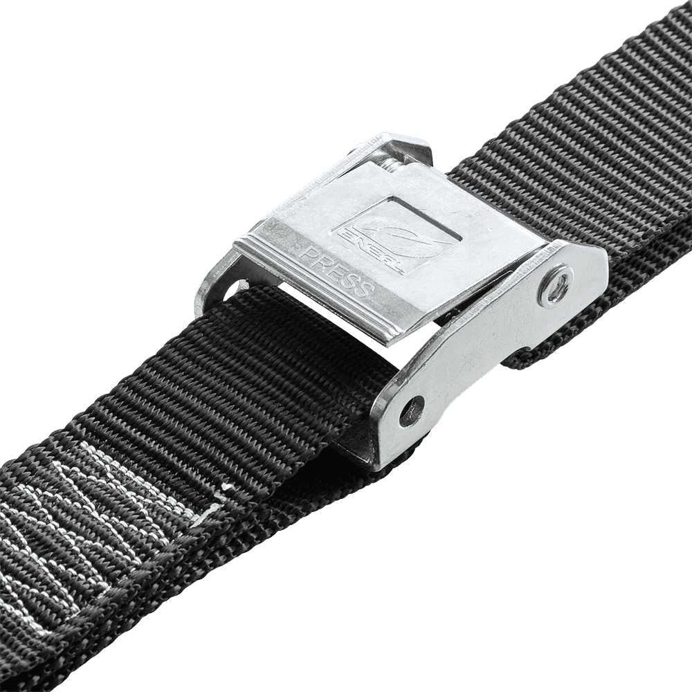 Eine Nahaufnahme des schwarzen O'NEAL DE LUXE Zurrgurte LOGO Gurtes mit silberner "PRESS" Nockenschnalle, perfekt für O'NEAL Motorrad oder Soft Hook Tie Downs, isoliert auf einem transparenten Hintergrund.