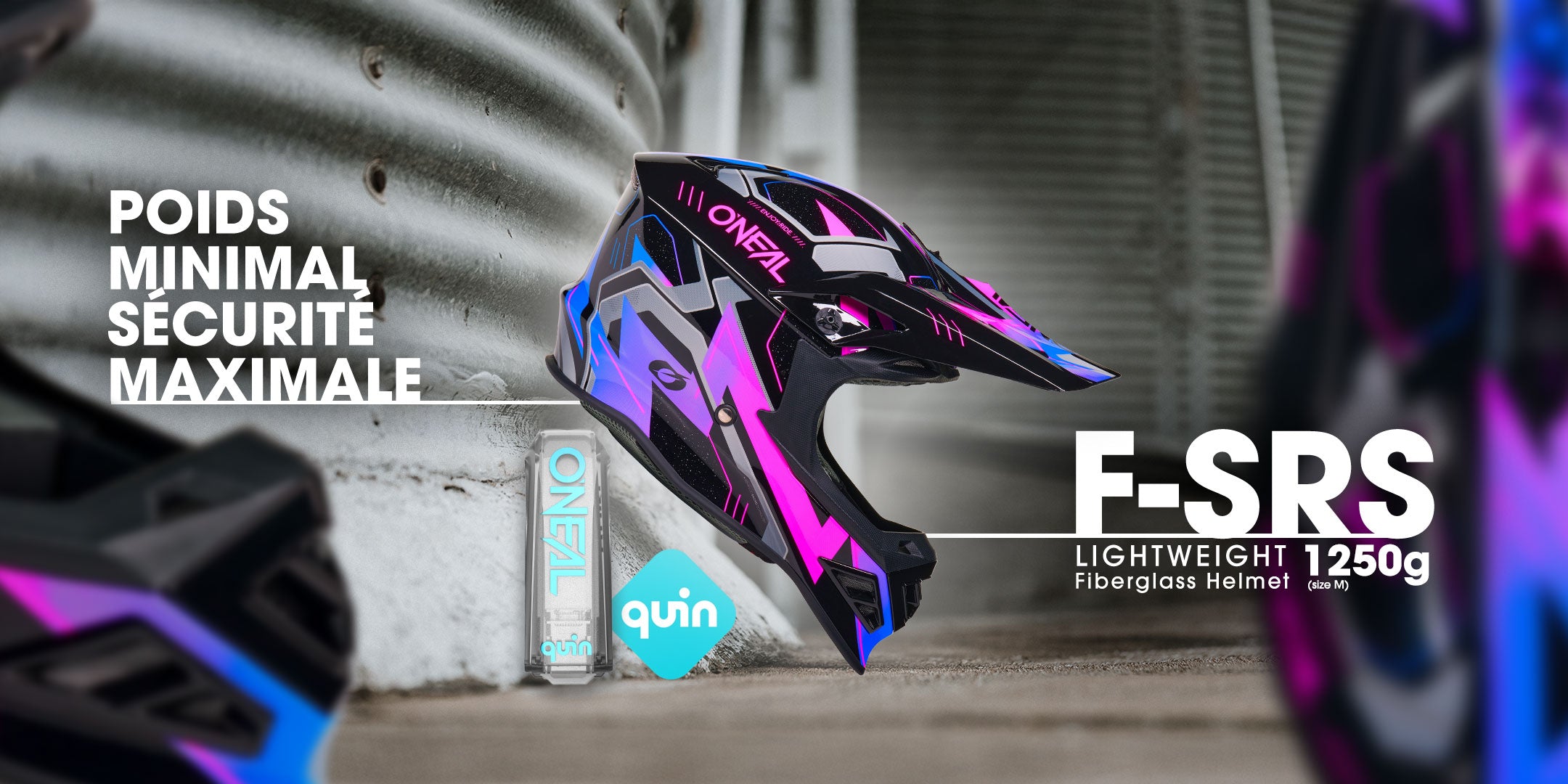 Ein farbenfroher ONZA F-SRS Vollvisierhelm mit blauem und rosa Design wird neben Dosen der Marken ONZA und Quin ausgestellt, wobei der französische Text minimales Gewicht und maximale Sicherheit hervorhebt. Das Gewicht wird mit 1250 g angegeben.