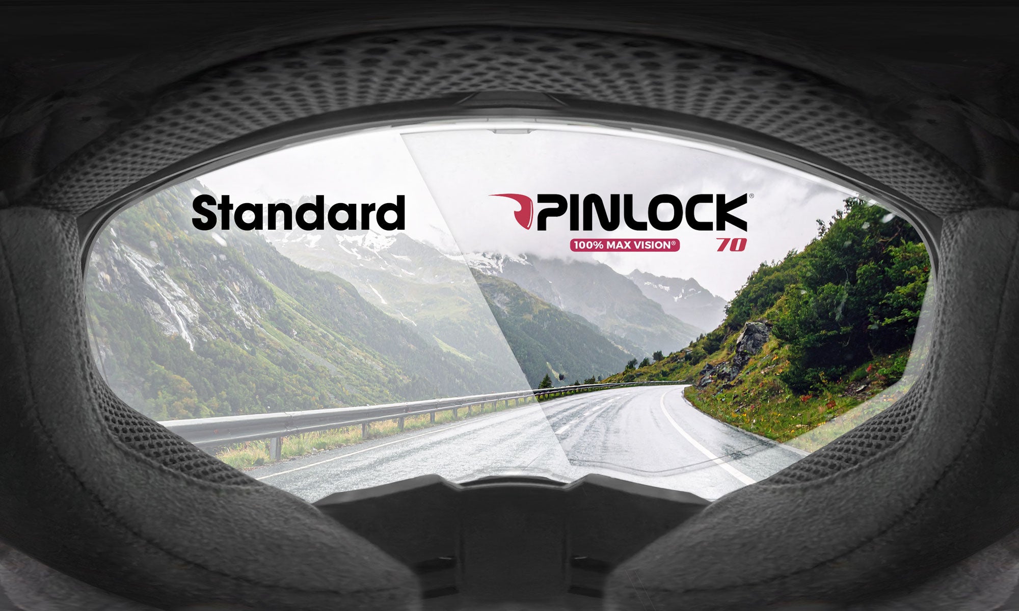 Blick aus dem Inneren eines Helms durch ein Visier, das eine Straße und Berge zeigt. Die linke Seite mit der Aufschrift "Standard" ist beschlagen, während die rechte Seite mit der Aufschrift "Pinlock" klar ist, um die Klarheit des Visiers zu demonstrieren.