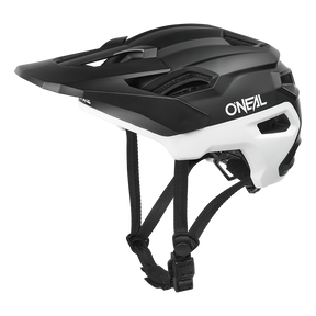 Der O'NEAL TRAILFINDER EVO Helm SOLID in Schwarz und Weiß verfügt über ein Visier, Belüftungslöcher und verstellbare Kinnriemen, dargestellt von der Seite auf weißem Hintergrund.