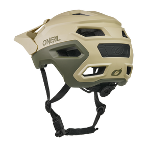Ein hellbrauner und olivgrüner O'NEAL TRAILFINDER EVO Helm SOLID mit Visier, Belüftungslöchern, verstellbaren schwarzen Kinnriemen und einem hinteren Einstellrad ist auf einem weißen Hintergrund abgebildet.