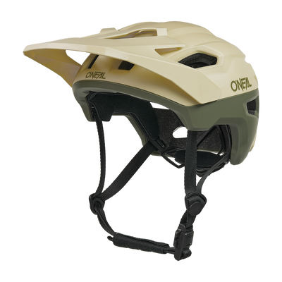 Der O'NEAL TRAILFINDER EVO Helm SOLID ist ein beiger und olivgrüner Mountainbike-Helm mit einem Visier, mehreren Belüftungsöffnungen, verstellbaren schwarzen Kinnriemen und ist mit dem optionalen Quin Smart Safety Sensor kompatibel.