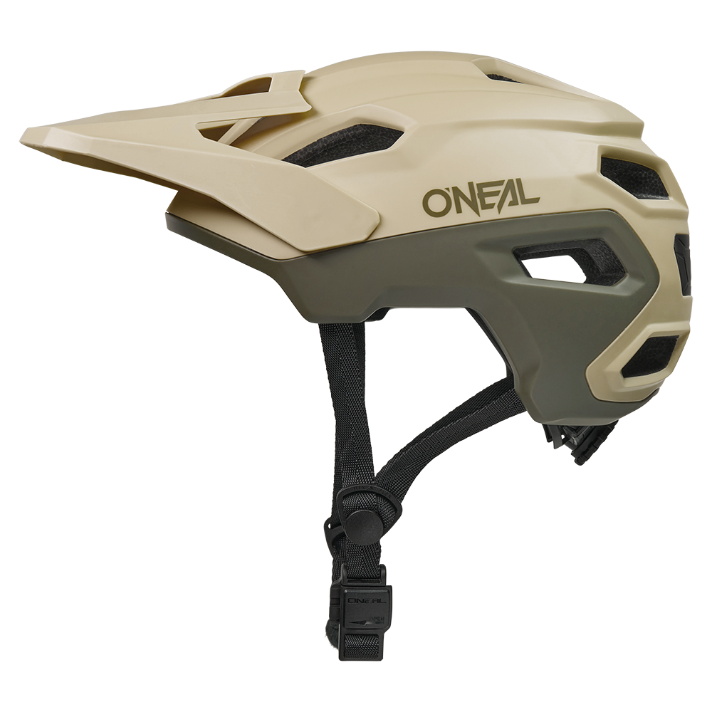 Seitenansicht eines O'NEAL TRAILFINDER EVO Helms SOLID in Beige und Olivgrün mit eckigen Belüftungsöffnungen, einem Visier und verstellbaren schwarzen Kinnriemen von O'NEAL, dargestellt vor einem schlichten weißen Hintergrund.