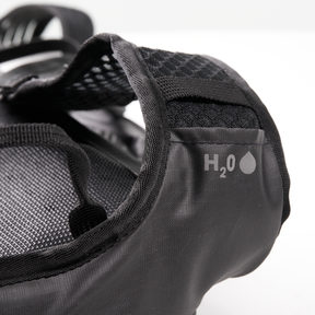 Close-up of the O'NEAL JUNCTION Protective Backpack from O'NEAL Europe features a black mesh pocket with "H₂O" written on it and a droplet symbol highlighting the hydration container or water bottle compartment.