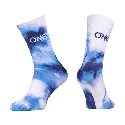 Dos calcetines de alto rendimiento O'NEAL MTB TWIST en azul/blanco con un llamativo "ONE" en la zona superior y diseño tie-dye azul. Elegantes y duraderos, son perfectos para cualquier aventura en bicicleta de montaña.