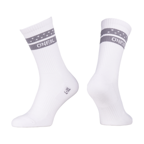 Zwei weiße O'NEAL MTB Performance Socke SOLID mit grauen Streifen und kleinen weißen Punkten am oberen Rand. "O'NEAL" ist in weiß auf dem Streifen gedruckt. Angezeigt auf unsichtbaren Fuß Formen vor einem weißen Hintergrund.