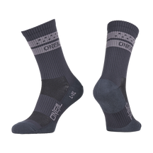 Ein Paar O'NEAL MTB Performance Socken SOLID in grau mit hellgrauen Bändern und "O'NEAL"-Schriftzug auf dem Bündchen und dem Fuß, von der Seite und in einem Winkel gezeigt, um sowohl die Vorder- als auch die Rückseite zu zeigen.