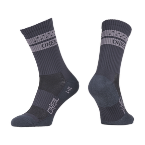 Ein Paar O'NEAL MTB Performance Socken SOLID in grau mit hellgrauen Bändern und "O'NEAL"-Schriftzug auf dem Bündchen und dem Fuß, von der Seite und in einem Winkel gezeigt, um sowohl die Vorder- als auch die Rückseite zu zeigen.