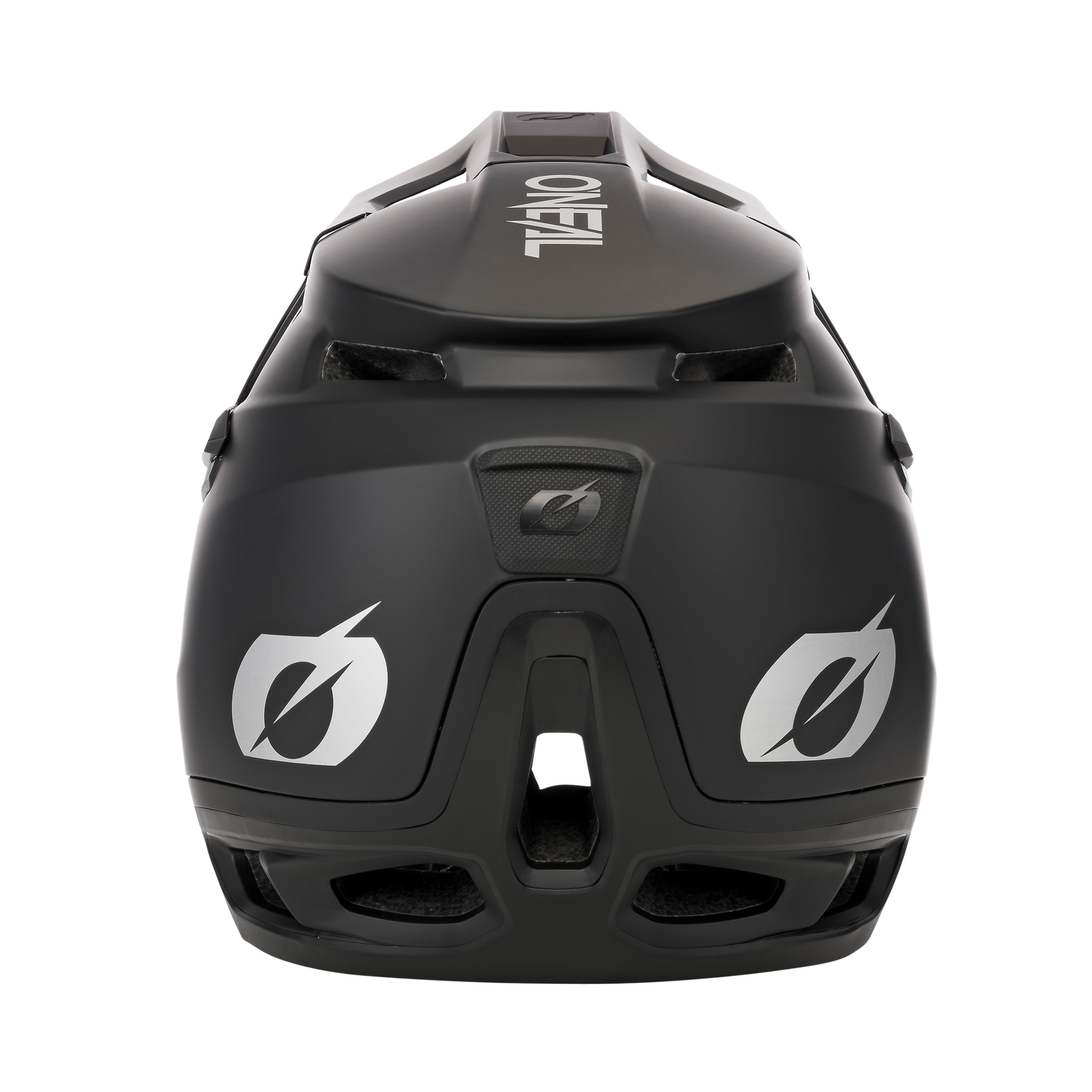 Ein schwarzer O'NEAL TRANSITION Helm SOLID wird mit Fokus auf seiner Rückseite angezeigt. Der Helm verfügt über weiße Logos auf der Rückseite, Belüftungsöffnungen und ein schlankes, aerodynamisches Design. Der schwarze Hintergrund betont die Merkmale des Helms und verleiht ihm ein modernes und stilvolles Aussehen, das Schutz gewährleistet.