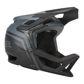 Der O'NEAL TRANSITION Helm FLASH von O'Neal ist ein schwarz-grauer Integralhelm für Mountainbikes mit aerodynamischem Design und erweitertem Kinnschutz. Er verfügt über eine matte Oberfläche mit „O'Neal“-Schriftzug in weißen Buchstaben für einen eleganten Look und bietet optimalen Schutz sowie Belüftungsöffnungen für die Luftzirkulation und eine bequeme Polsterung im Inneren.