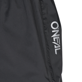 Nahaufnahme einer schwarzen O'NEAL TORRENT Regenhose mit dem weißen "O'NEAL"-Logo entlang einer Naht. Entworfen für Sport und Outdoor.