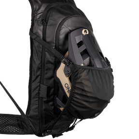 Der O'NEAL JUNCTION Protektorrucksack von O'NEAL Europe ist ein schwarzer Bikerrucksack mit einer Außentasche aus Mesh zur Befestigung eines beigen oder schwarzen Helms. Er bietet gepolsterte Schultergurte und ein strukturiertes, stilvolles Design für Komfort auf jeder Fahrt.