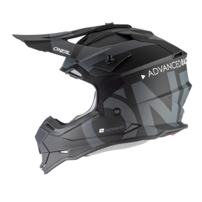 Ein mattschwarzer O'NEAL 2SRS Helm SLICK mit dem „O'Neal“-Logo auf dem Visier und dem „ADVANCED RACE“-Text an der Seite. Dieser Helm zeigt eckige Designelemente mit grauen Grafiken, eine Belüftungsöffnung oben und einen Kinnschutz mit der auffälligen Aufschrift „2SRS“.