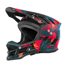 Der O'NEAL BLADE Polyacrylite Helm RIO ist ein schwarz-roter Motocross-Helm, der mit tropischen Blumenmustern verziert ist. Er zeichnet sich durch kräftige geometrische Formen und leuchtende Farben wie Blau, Grün, Gelb und Weiß sowie den O'NEAL-Markentext auf der Seite aus. Das Design verfügt über Belüftungsöffnungen für höchsten Komfort.