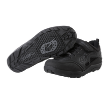 Ein Paar O'NEAL TRAVERSE SPD-Schuhe in Schwarz, ideal für Motorsport-Zubehör, vor weißem Hintergrund. Ein Schuh ist so positioniert, dass das untere Profil mit einem markanten kreisförmigen Griffmuster für perfekten Halt hervorgehoben wird, während der andere Schuh das Seitenprofil und die Schnürsenkel hervorhebt und mit dem O'NEAL-Markenlogo und einem Klettverschluss versehen ist.