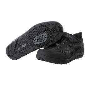 Ein Paar O'NEAL TRAVERSE SPD-Schuhe in Schwarz, ideal für Motorsport-Zubehör, vor weißem Hintergrund. Ein Schuh ist so positioniert, dass das untere Profil mit einem markanten kreisförmigen Griffmuster für perfekten Halt hervorgehoben wird, während der andere Schuh das Seitenprofil und die Schnürsenkel hervorhebt und mit dem O'NEAL-Markenlogo und einem Klettverschluss versehen ist.
