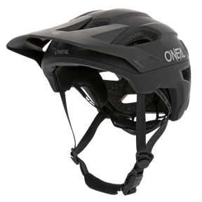 Der O'NEAL TRAILFINDER Helm SOLID in Schwarz verfügt über ein verstellbares Visier, Kinnriemen und ein aerodynamisches Design. Für zusätzlichen Komfort und Schutz verfügt er über Belüftungslöcher und eine Innenpolsterung. Das O'Neal-Logo ist sowohl an der Seite als auch an der Vorderseite des Helms deutlich sichtbar.