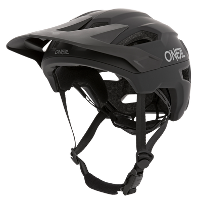 Der O'NEAL TRAILFINDER Helm SOLID in Schwarz verfügt über ein verstellbares Visier, Kinnriemen und ein aerodynamisches Design. Für zusätzlichen Komfort und Schutz verfügt er über Belüftungslöcher und eine Innenpolsterung. Das O'Neal-Logo ist sowohl an der Seite als auch an der Vorderseite des Helms deutlich sichtbar.