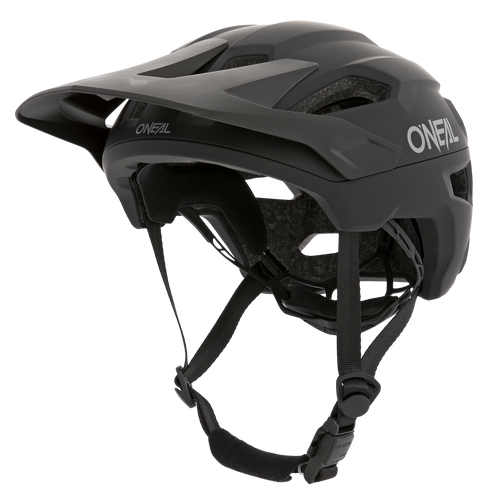 Der O'NEAL TRAILFINDER Helm SOLID in Schwarz verfügt über ein verstellbares Visier, Kinnriemen und ein aerodynamisches Design. Für zusätzlichen Komfort und Schutz verfügt er über Belüftungslöcher und eine Innenpolsterung. Das O'Neal-Logo ist sowohl an der Seite als auch an der Vorderseite des Helms deutlich sichtbar.