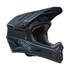 Ein mattschwarzer O'NEAL BACKFLIP Helm SOLID mit stromlinienförmigem Design mit Belüftungslamellen und „O'NEAL“-Branding an der Seite. Dieser Integralhelm für MTB ist für Komfort und Schutz mit gepolstertem Material gefüttert und damit die ideale Wahl für Mountainbike-Experten, die Sicherheit suchen.