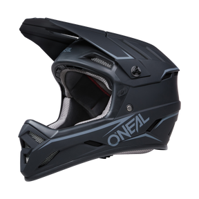 Der O'NEAL BACKFLIP Helm SOLID ist ein mattschwarzer Integralhelm mit weißem und grauem „ONEAL“-Branding an der Seite, perfekt für MTB-Enthusiasten. Sein Design umfasst mehrere Lüftungsschlitze für optimale Belüftung und ein robustes Visier oben. Die Innenausstattung verfügt über eine hellgraue Polsterung für maximalen Komfort und bietet die von Mountainbike Experten empfohlene Sicherheit.
