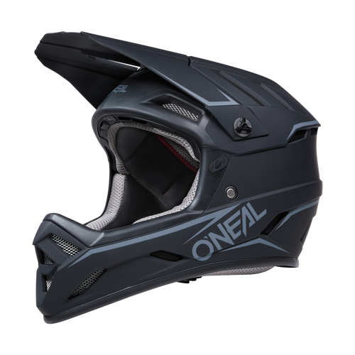 Der O'NEAL BACKFLIP Helm SOLID ist ein mattschwarzer Integralhelm mit weißem und grauem „ONEAL“-Branding an der Seite, perfekt für MTB-Enthusiasten. Sein Design umfasst mehrere Lüftungsschlitze für optimale Belüftung und ein robustes Visier oben. Die Innenausstattung verfügt über eine hellgraue Polsterung für maximalen Komfort und bietet die von Mountainbike Experten empfohlene Sicherheit.