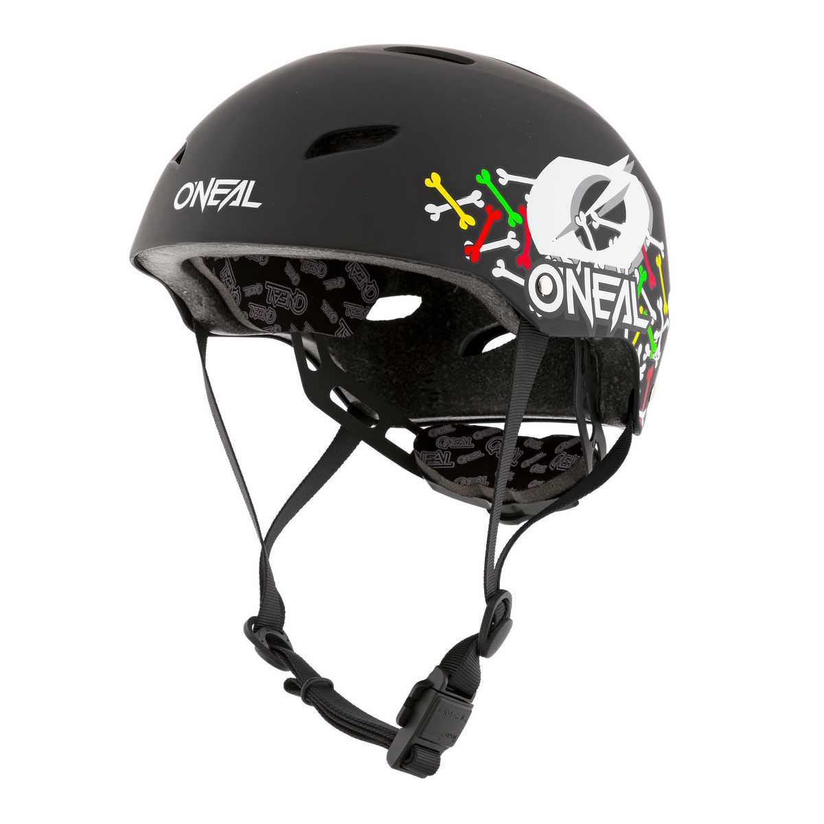 Ein O'NEAL DIRT LID Helm Kinder SKULLS von O'NEAL mit farbenfrohen Grafiken an der Seite und oben. Dieser schwarze Helm hat ein mattes Finish, Belüftungslöcher, einen verstellbaren Kinnriemen mit Schnalle und eine Innenpolsterung mit aufgedruckten Mustern für Komfort und Schutz.