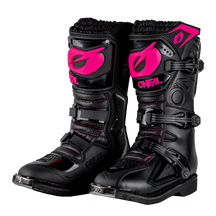 Ein Bild der O'NEAL RIDER PRO Stiefel Kinder, ein Paar schwarze Motocross-Stiefel mit rosa und schwarzen Details. Die Stiefel haben große Schnallen, dicke Sohlen und den Markennamen „O'NEAL“ sowie ein stilisiertes rosa „O“-Logo. Diese Stiefel wurden entwickelt, um Schutz und Halt beim Offroad-Motorradfahren zu bieten und sind für junge Fahrer sowohl funktional als auch stilvoll.