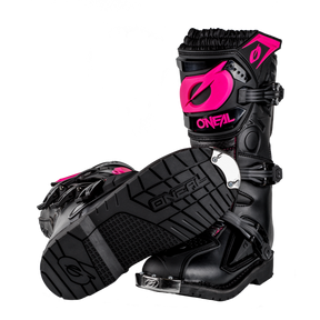 Wir präsentieren die O'NEAL RIDER PRO Stiefel Kinder – diese eleganten schwarzen Motocross-Stiefel verfügen über stilvolle rosa Akzente, darunter Logos und aufwendige Details. Die von O'NEAL entworfenen Stiefel verfügen über robuste, strukturierte Sohlen für hervorragenden Halt und mehrere Schnallen für einen sicheren Sitz. Ein Stiefel wird aufrecht stehend präsentiert, während der andere auf der Seite liegt, wodurch die strapazierfähige Sohle hervorgehoben wird.