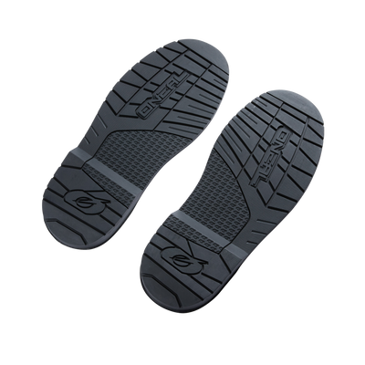 Zwei schwarze Sohlen aus dem O'NEAL RIDER PRO Youth Boot Spare Sole Set sind nebeneinander auf einem weißen Hintergrund platziert. Die Sohlen weisen verschiedene strukturierte Muster für den Halt auf, darunter erhabene Rippen und ein kompliziertes Gittermuster im Mittelteil. Der Markenname „O'NEAL“ ist auf jeder Sohle deutlich sichtbar.