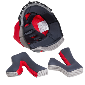 Ein O'NEAL Liner & Cheek Pads SONUS Helm mit fester Polsterung wird mit seinen einzelnen Innenteilen vor einem weißen Hintergrund abgebildet. Die Komponenten sind dunkelgrau mit einem roten Innenfutter aus Mesh und mit weißen Kanten strukturiert, während das O'NEAL-Label im Inneren des Helms sichtbar, aber nicht vollständig lesbar ist.