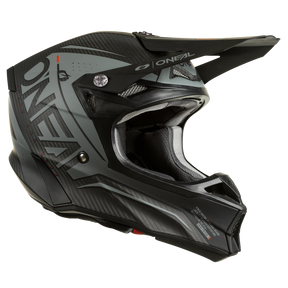 Der O'NEAL 10SRS Carbon Helm PRODIGY ist ein schwarz-grauer Integralhelm für Motocross, der an der Seite deutlich die Marke „O'Neal“ zeigt. Dieser bemerkenswert leichte Carbonhelm mit Kohlefaser-Außenschalen verfügt über ein Visier, ein detailliertes Design mit Belüftungsöffnungen und strukturierte Muster für optimale Leistung.