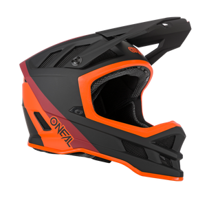 Ein schwarz-orangefarbener Integralhelm für Mountainbikes mit mattem Finish, eckigen Belüftungsöffnungen und Kinnschutz. Der Markenname O'NEAL ist in orangefarbenen Buchstaben auf der Seite zu sehen. Dieser elegante, aerodynamische O'NEAL BLADE Hyperlite Helm CHARGER besticht durch eine Mischung aus schwarzen, orangefarbenen und kastanienbraunen Akzenten.