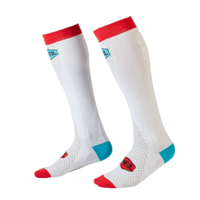 Ein stylisches Paar weiße kniehohe O'NEAL MX Performance Socke MINUS mit roten Bündchen und Zehenbereichen, blauen Akzenten an den Fersen und einem kombinierten blau-roten O'NEAL-Logo im Wadenbereich. Diese Socken stehen auf einem schwarzen Hintergrund und sind daher perfekt für Motocross-Fans, die sowohl Stil als auch Funktion suchen.