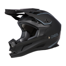 Der O'NEAL DROP DH Helm SOLID ist ein mattschwarzer Integralhelm mit blaugrauen Akzenten. Er verfügt über ein eckiges Visier und einen Kinnschutz, auf dessen Seite der Markenname „O'Neal“ in Weiß zu sehen ist. Dieser aerodynamische Helm ist für das Offroad-Biken konzipiert und bietet sowohl Sicherheit als auch Komfort.