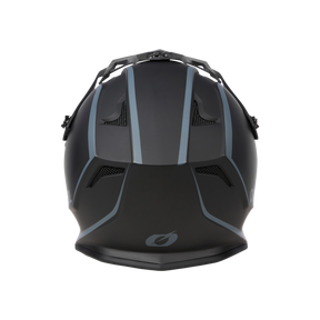 Von vorne betrachtet besticht der O'NEAL DROP DH Helm SOLID – ein schwarz-grauer Mountainbike-Helm von O'NEAL – durch sein aerodynamisches Design. Er verfügt über mehrere Belüftungsöffnungen und eine Innenpolsterung, die sowohl Sicherheit als auch Komfort gewährleistet. Am unteren Ende des Helms ist ein stilvolles Emblem zu sehen, das sich von einem schwarzen Hintergrund abhebt.