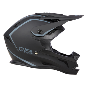 Schwarz-grauer Offroad-Motorradhelm mit blauen Akzenten, mit Integraldesign, großem Visier und Belüftungsöffnungen. Der Markenname „O'Neal“ ist deutlich sichtbar auf der Seite dieses O'NEAL DROP DH Helm SOLID zu sehen. Dieser moderne und robuste Helm bietet sowohl Sicherheit als auch Komfort und ist auf einem schwarzen Hintergrund zu sehen.