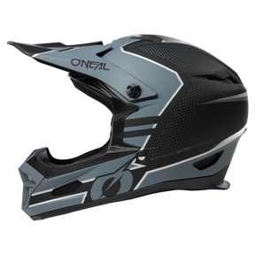 Ein schwarz-grauer Integralhelm O'NEAL FURY STAGE mit eckigem Design und dem Markennamen „O'Neal“ an der Seite. Der Helm verfügt über ein Visier, Belüftungspunkte und trägt am unteren Rand den Text „Advanced Racing Technology“, was sowohl Sicherheit als auch Leistung bietet.