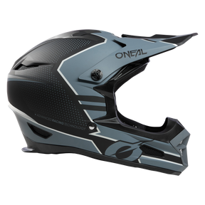 Eine Seitenansicht des O'NEAL FURY Helm STAGE in Mattschwarz und Grau zeigt fortschrittliche Renntechnologie. Dieser Integralhelm für Motorräder zeichnet sich durch eckige Designelemente, Belüftungsöffnungen und ein nach vorne verlängertes Visier aus. Um die Sicherheit zu gewährleisten, ist das O'Neal-Logo sowohl an der Seite als auch am Visier deutlich sichtbar angebracht.